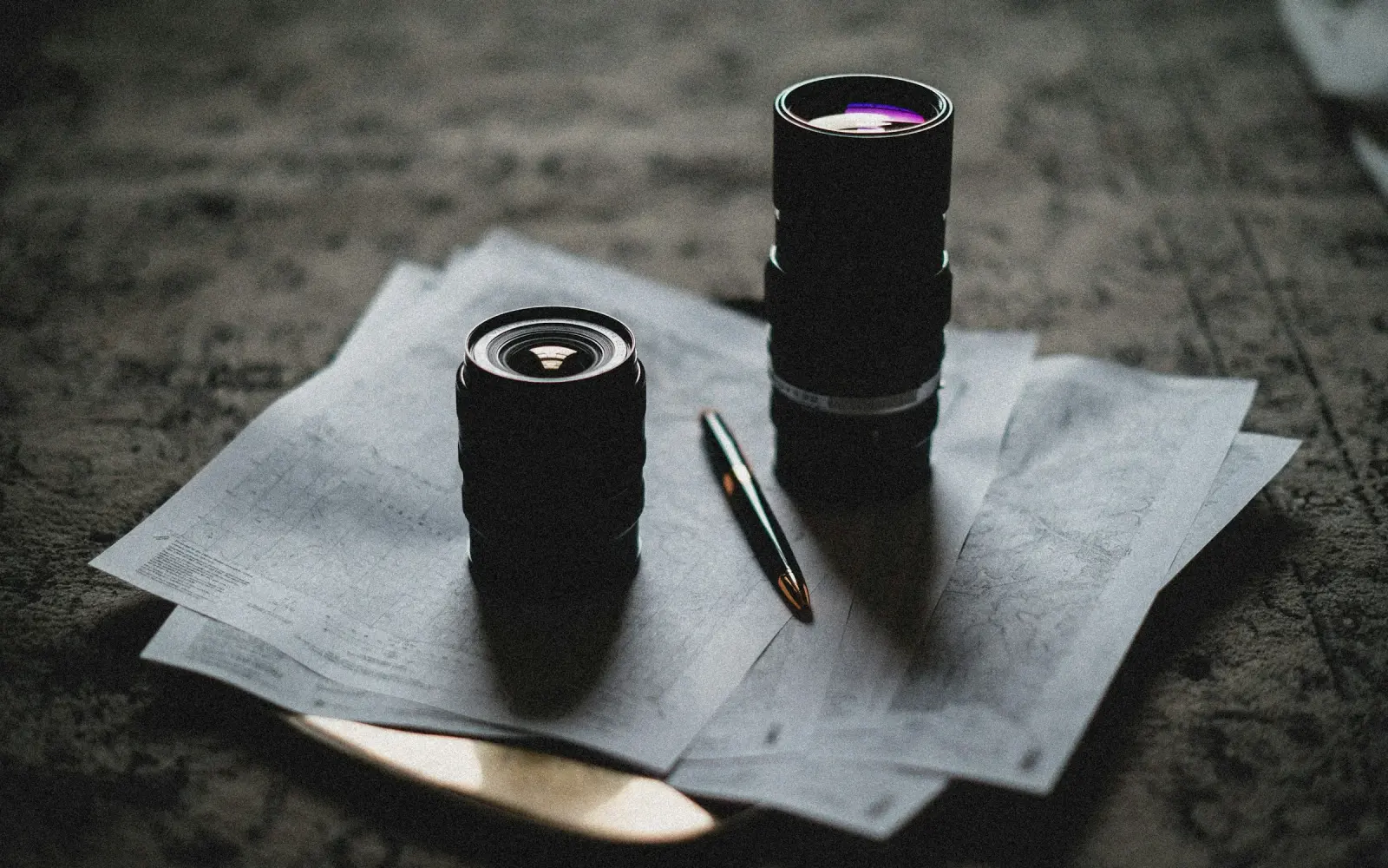 Camera lenses and editorial notes arranged on a work surface